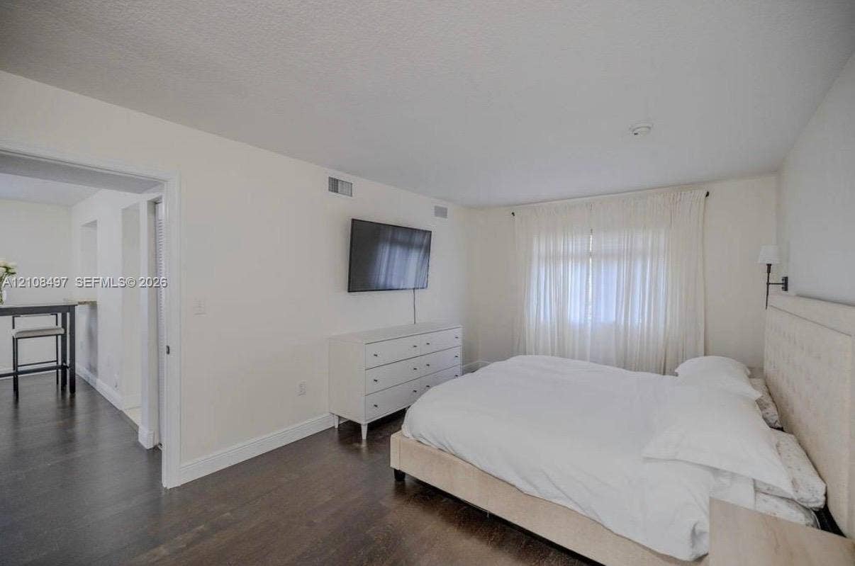 6245 SW 47th Manor, #101, Davie, FL 33314 Room featuring wood-finish flooring, neutral wall tones, and a wall-mounted light fixture