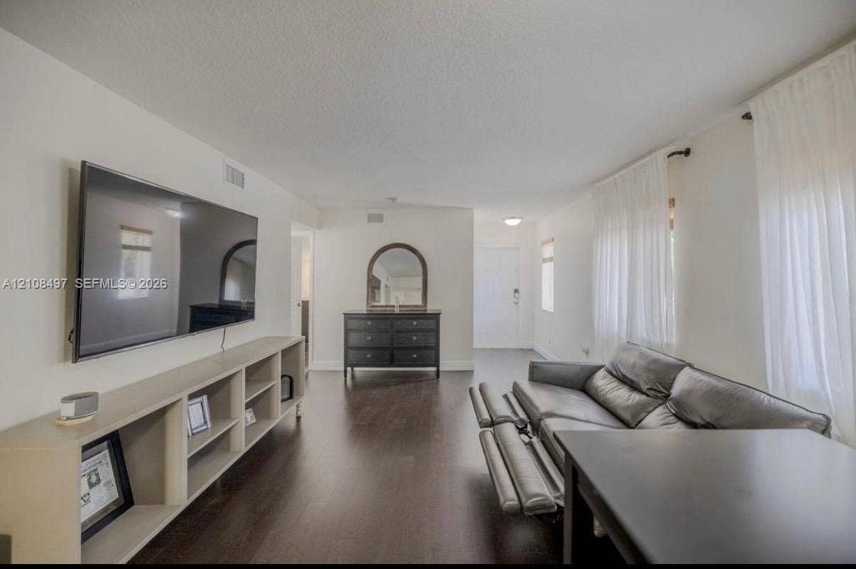 6245 SW 47th Manor, #101, Davie, FL 33314 Living space featuring wood-finish flooring, white walls, and built-in shelving