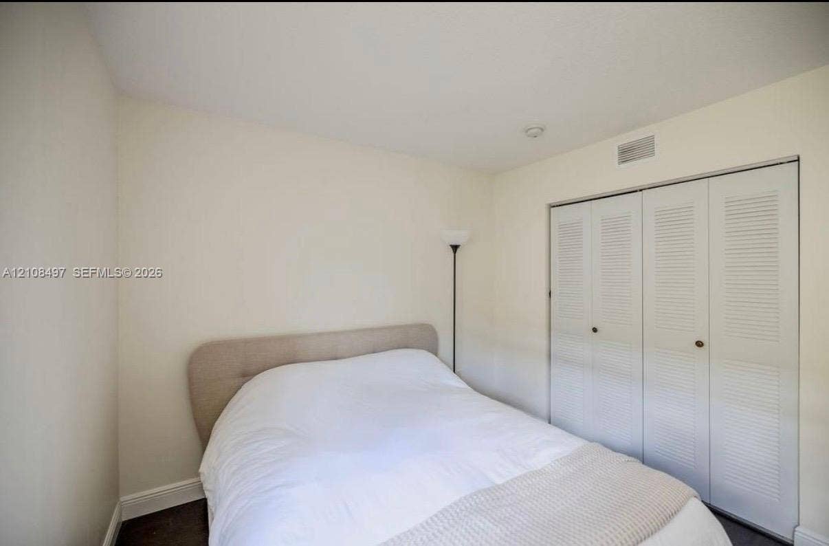 6245 SW 47th Manor, #101, Davie, FL 33314 Neutral-toned interior featuring walls with a smooth finish and a closet with white louvered bifold doors