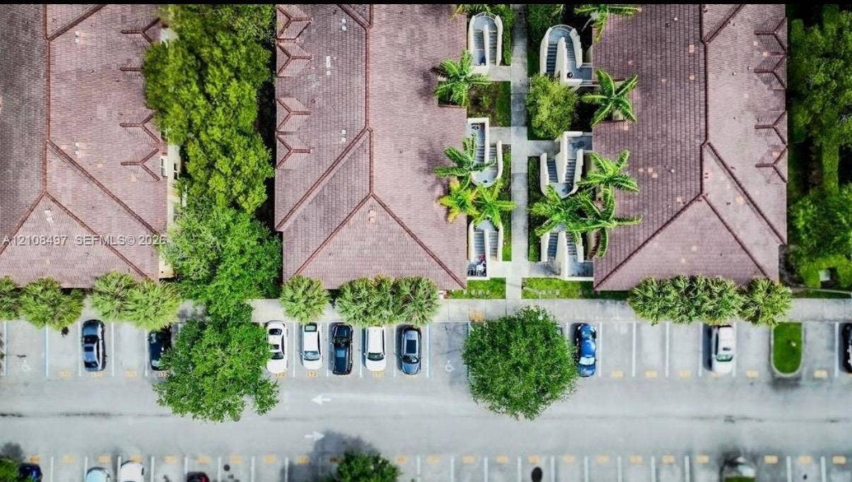 6245 SW 47th Manor, #101, Davie, FL 33314 Aerial perspective featuring tile-roofed buildings, paved parking surfaces, dedicated pedestrian walkways, and mature landscaping