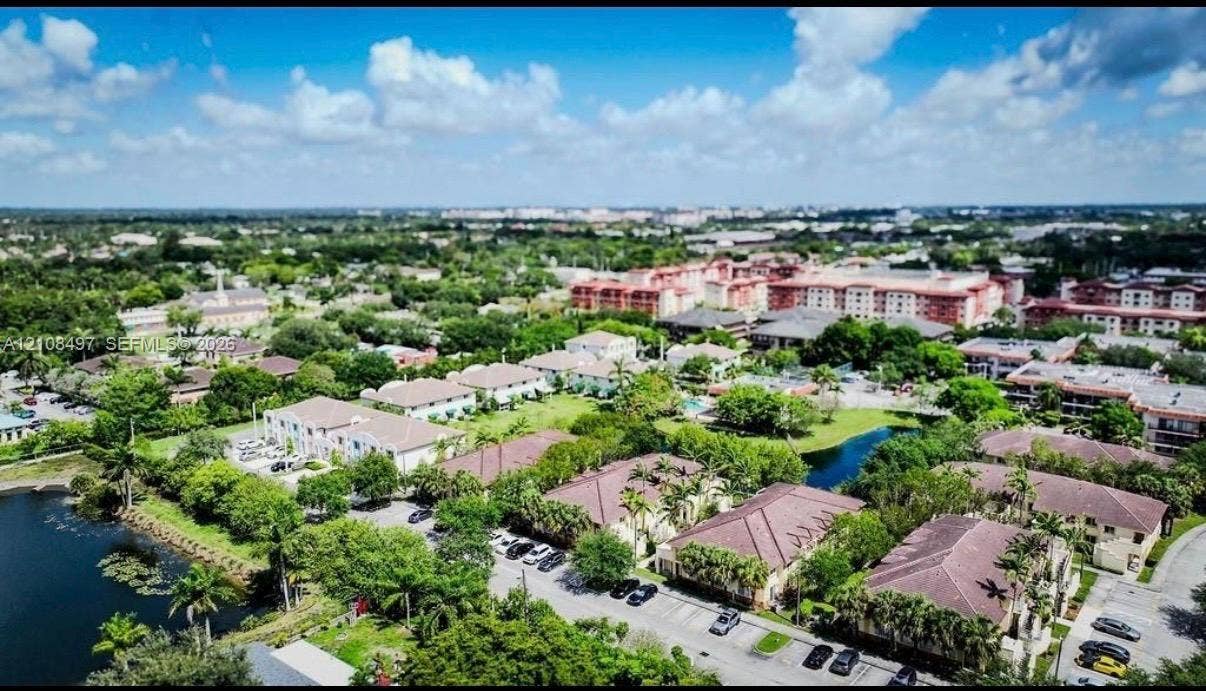 6245 SW 47th Manor, #101, Davie, FL 33314 Aerial perspective featuring multi-story residential buildings with hipped tile roofs, established tree canopy, and waterfront areas
