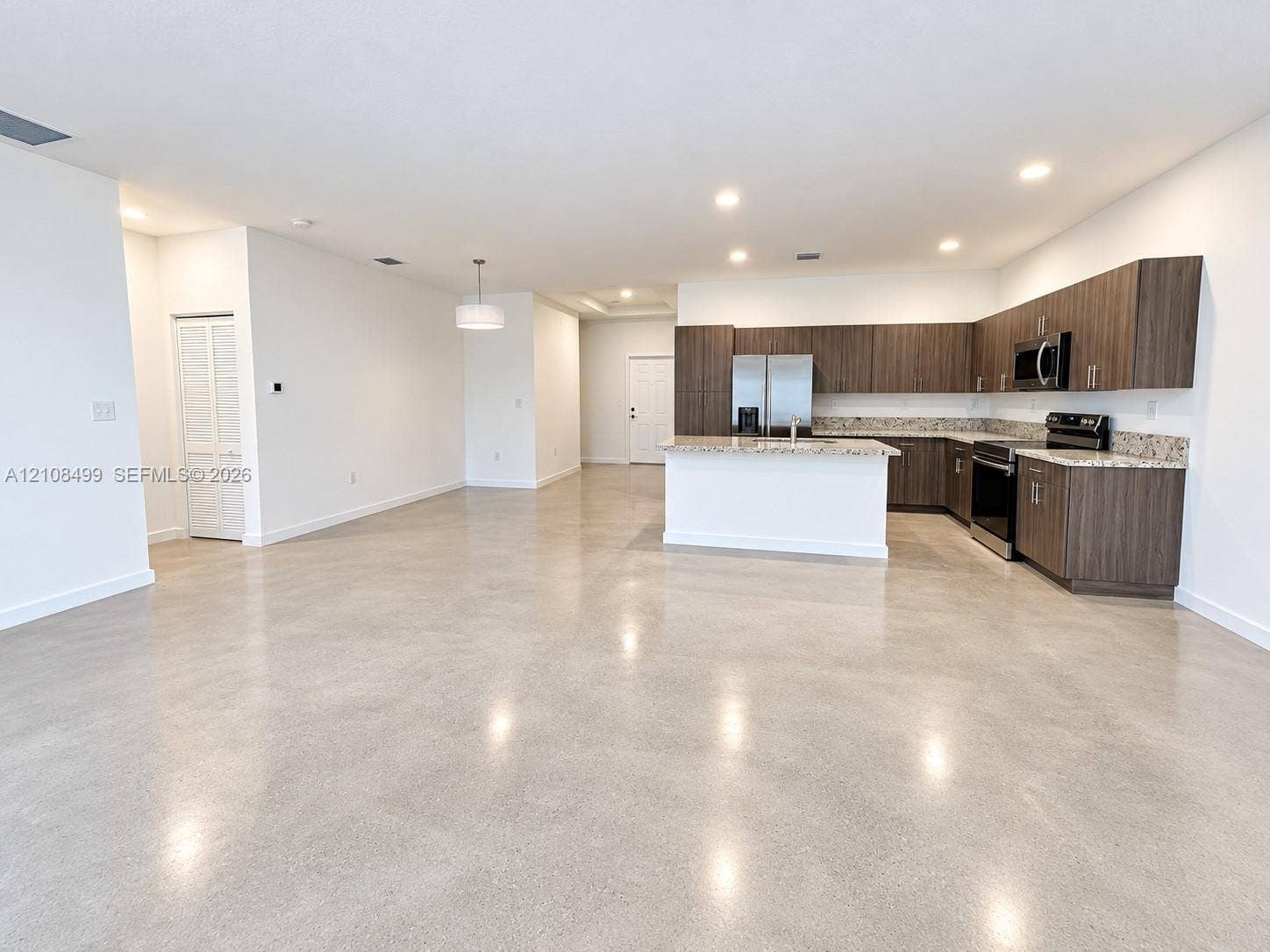 104 NW 31st Avenue, Fort Lauderdale, FL 33311 Polished concrete flooring, recessed lighting, horizontal wood-grain cabinetry, stone-surface countertops, and built-in stainless steel appliances