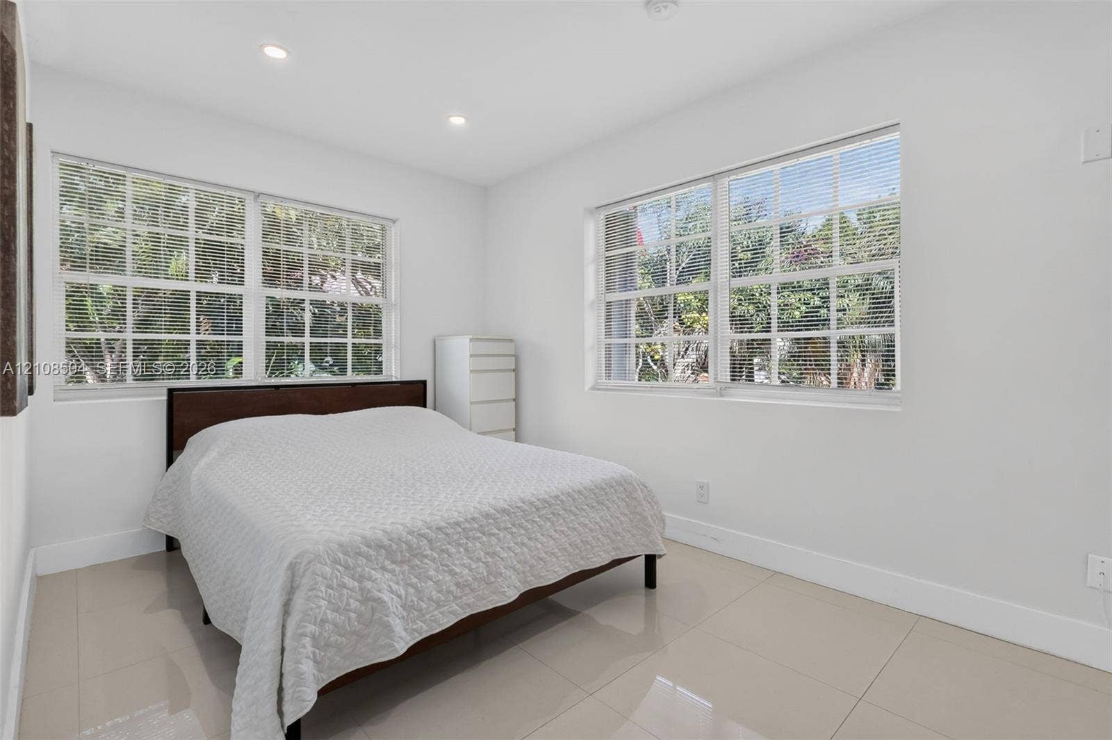 Neutral-toned ceramic tile flooring, recessed lighting, and multiple windows with grid detailing
