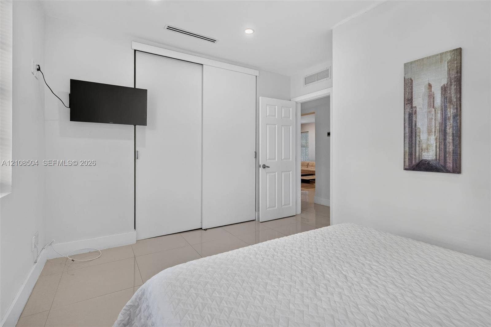 Neutral-toned ceramic tile flooring, sliding-door closet, recessed lighting, and six-panel interior door
