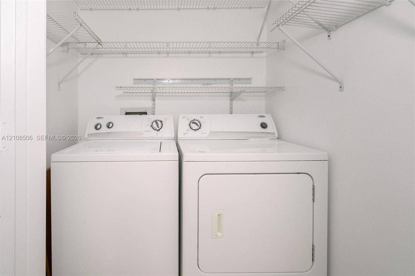 Laundry area featuring multi-level wire shelving and side-by-side appliances
