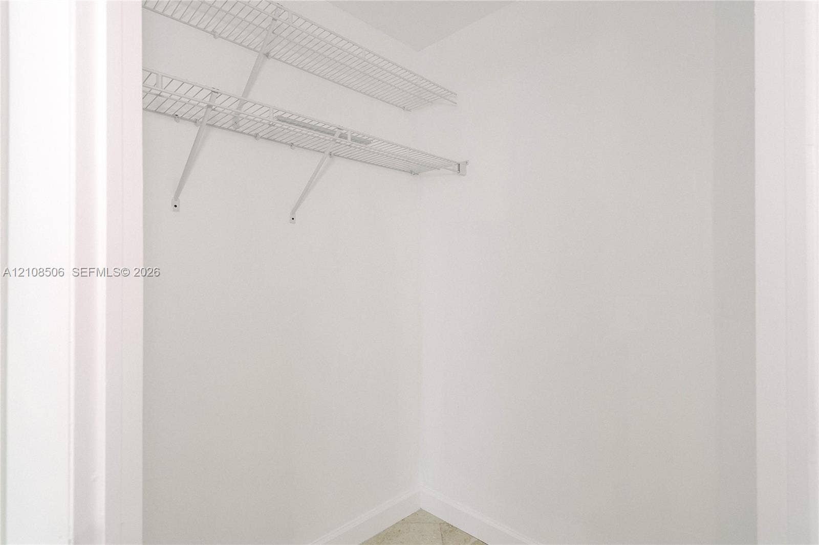 Storage area featuring dual-tiered white wire shelving