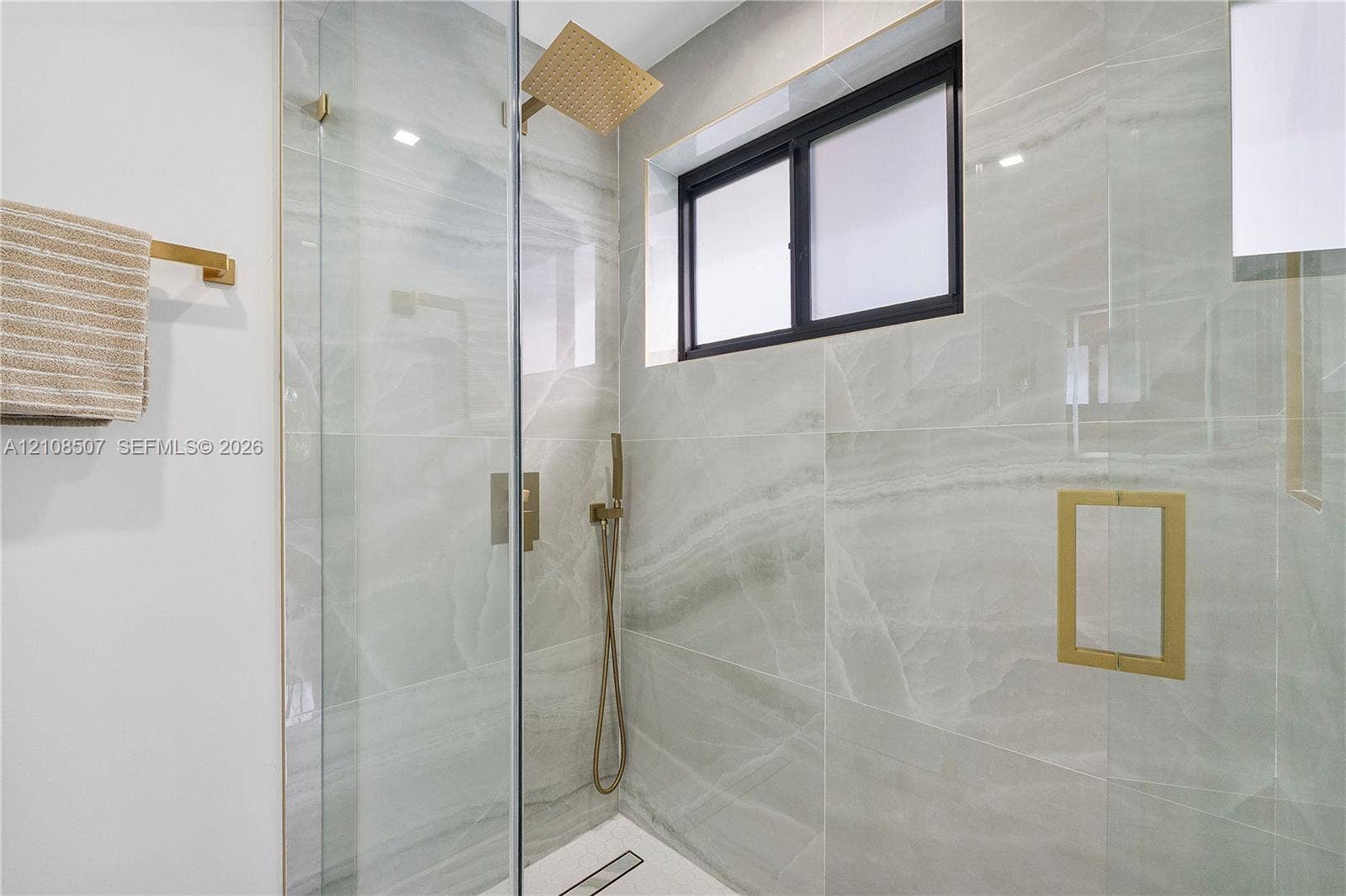 451 SW 38th Terrace, #1, Fort Lauderdale, Fort Lauderdale, FL 33312 Walk-in shower featuring floor-to-ceiling stone-finish tile, glass enclosure, gold-tone hardware, rainfall showerhead, and a rectangular niche