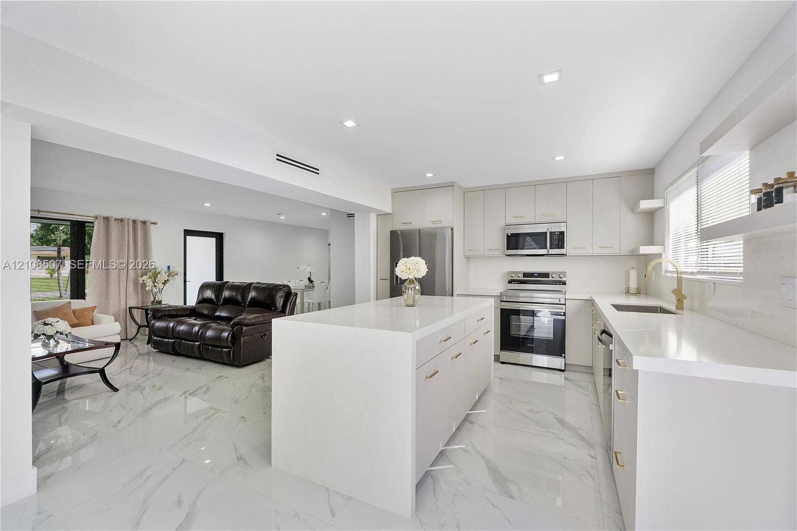 451 SW 38th Terrace, #1, Fort Lauderdale, Fort Lauderdale, FL 33312 Kitchen featuring a central island with a solid-surface countertop, flat-panel cabinetry, stainless steel appliances, and large-format porcelain tile flooring