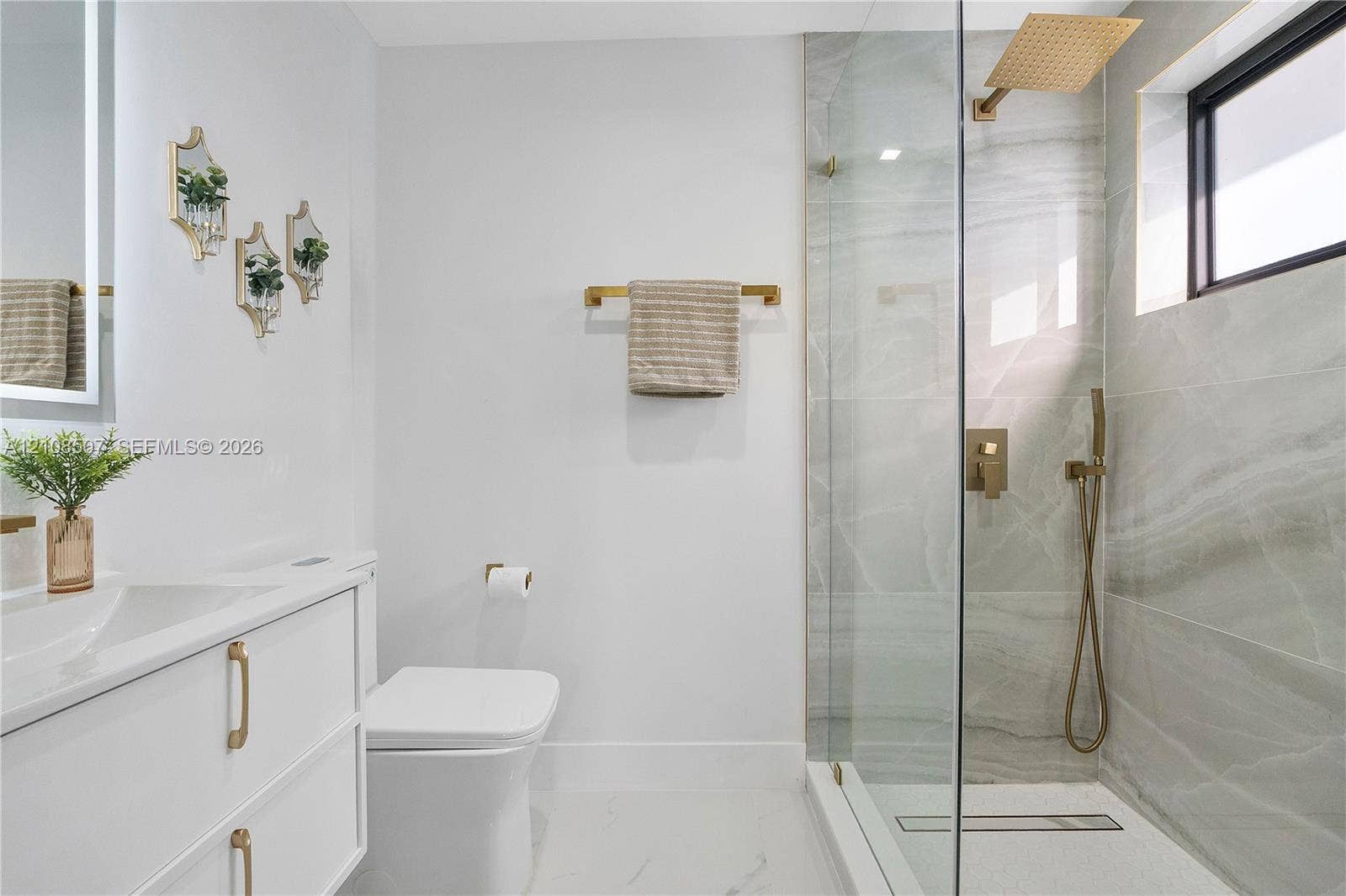 451 SW 38th Terrace, #1, Fort Lauderdale, Fort Lauderdale, FL 33312 Bathroom featuring a white vanity with gold-tone hardware, large-format tiled walk-in shower with a rain-style showerhead, and matching gold-tone fixtures