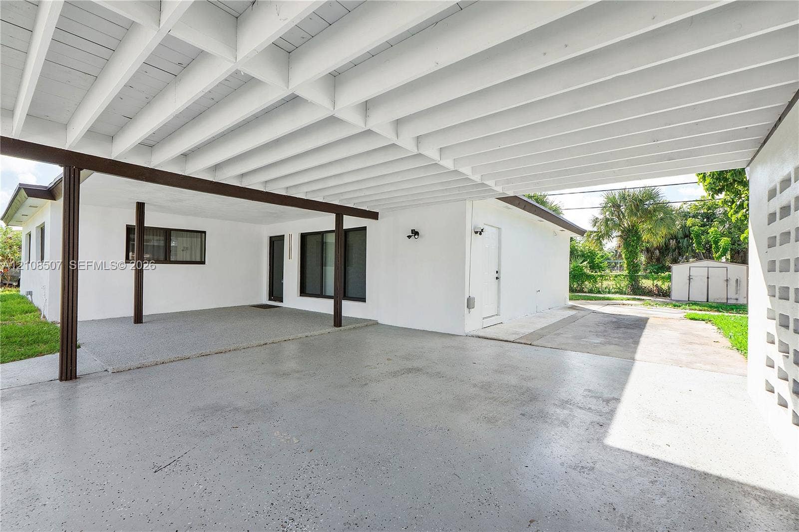 451 SW 38th Terrace, #1, Fort Lauderdale, Fort Lauderdale, FL 33312 Covered carport featuring an exposed beam ceiling, smooth-finish concrete flooring, and a decorative concrete block privacy screen