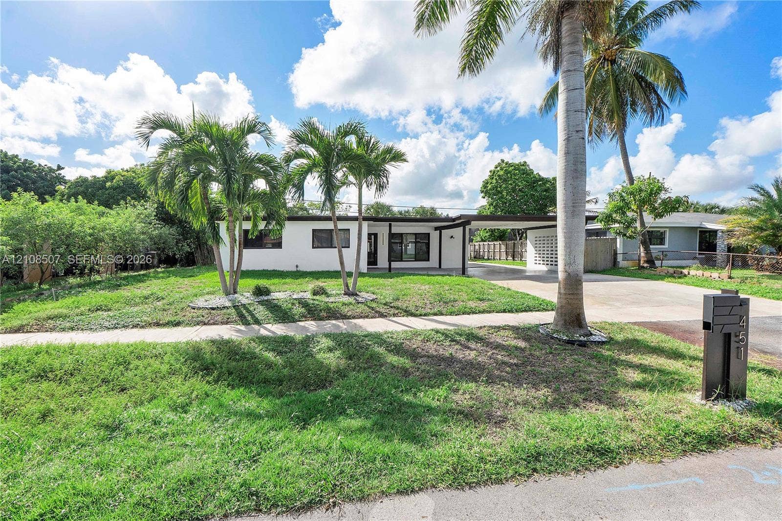 451 SW 38th Terrace, #1, Fort Lauderdale, Fort Lauderdale, FL 33312 Mid-century modern exterior featuring a flat roofline, white smooth-finish siding, integrated carport, decorative screen wall, and mature palms