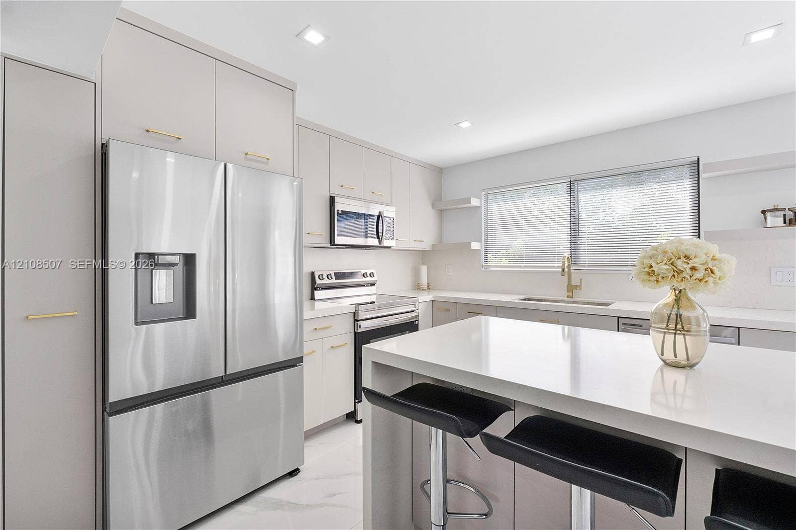 451 SW 38th Terrace, #1, Fort Lauderdale, Fort Lauderdale, FL 33312 Kitchen featuring flat-panel cabinetry with gold-tone hardware, a central island with a solid-surface countertop, stainless steel appliances, and recessed lighting