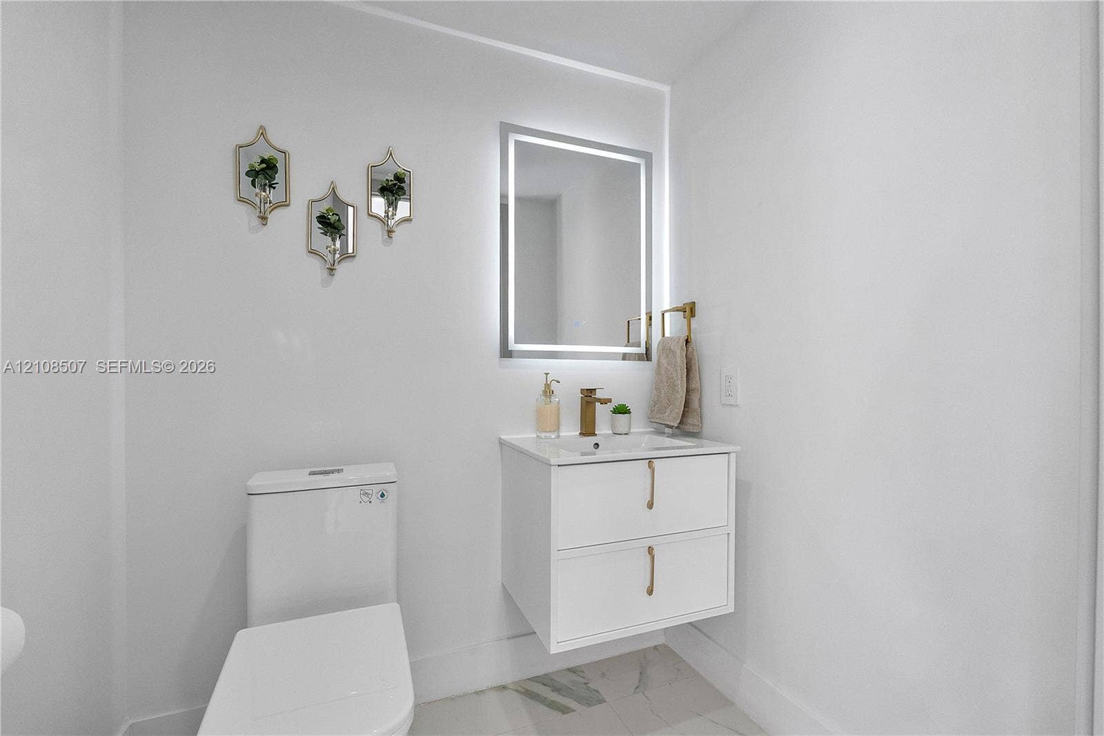 451 SW 38th Terrace, #1, Fort Lauderdale, Fort Lauderdale, FL 33312 Floating white vanity with double drawers, metallic hardware, integrated stone countertop, LED-backlit mirror, and gold-finish faucet