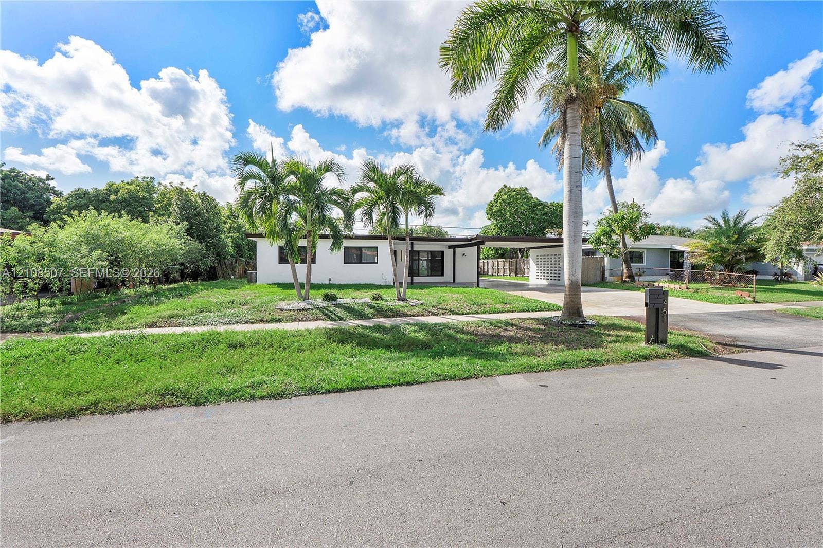 451 SW 38th Terrace, #1, Fort Lauderdale, Fort Lauderdale, FL 33312 Single-story residence featuring a white stucco exterior, attached carport with decorative breeze block screen, concrete driveway, and mature palm trees