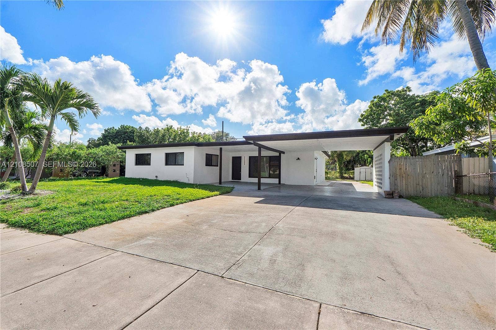 451 SW 38th Terrace, #1, Fort Lauderdale, Fort Lauderdale, FL 33312 Single-story exterior featuring a painted stucco facade, attached covered carport, concrete driveway, and decorative breeze block privacy screen