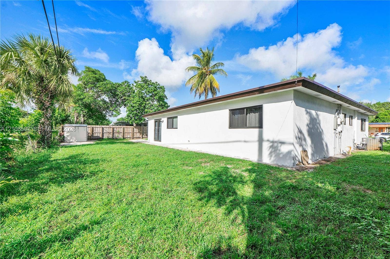 451 SW 38th Terrace, #1, Fort Lauderdale, Fort Lauderdale, FL 33312 Expansive backyard featuring a large grass lawn, mature palm trees, and perimeter wood fencing