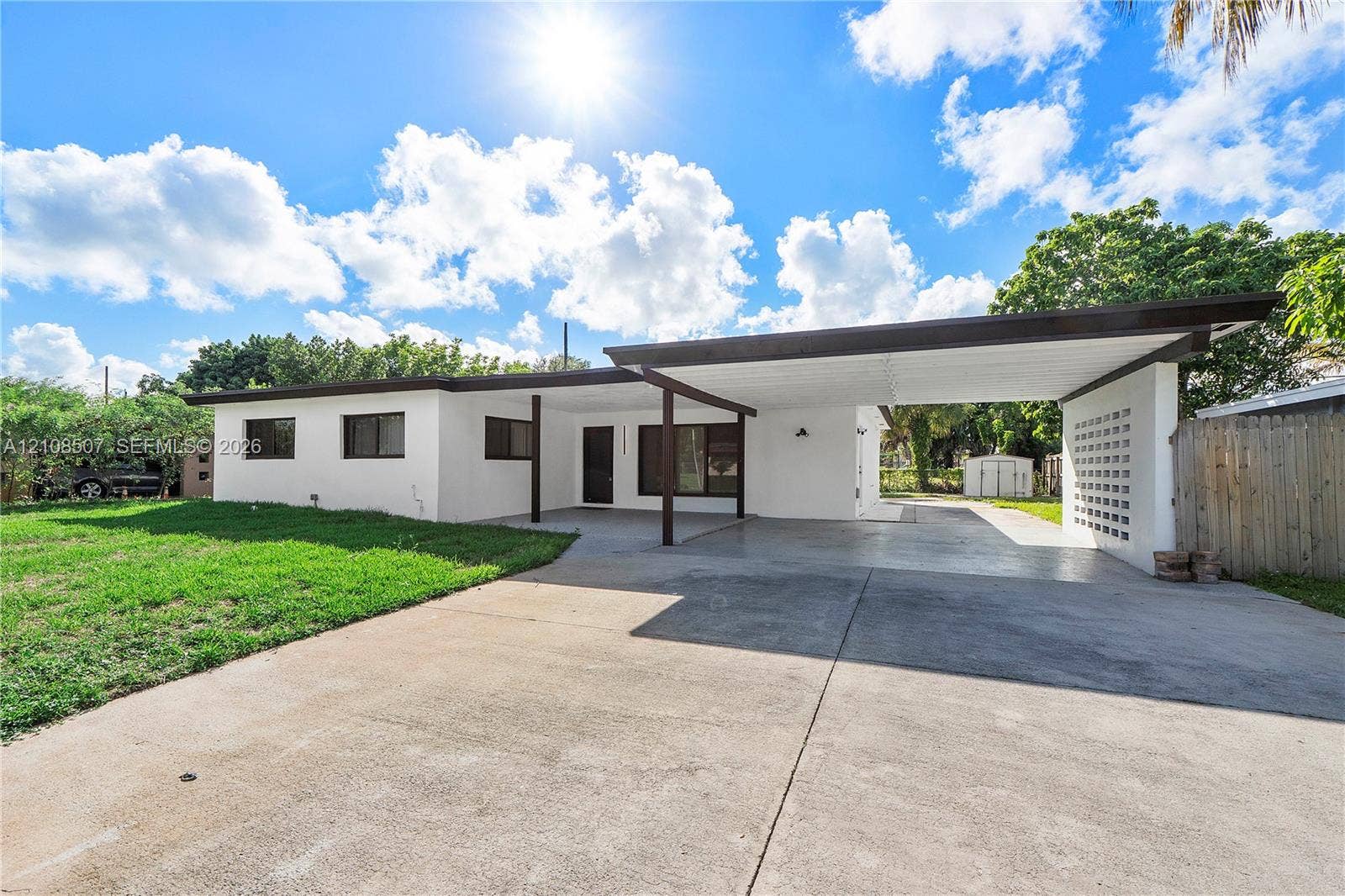 451 SW 38th Terrace, #1, Fort Lauderdale, Fort Lauderdale, FL 33312 Single-story residence featuring a smooth stucco exterior, attached flat-roof carport, decorative concrete block screening, and an expansive concrete driveway