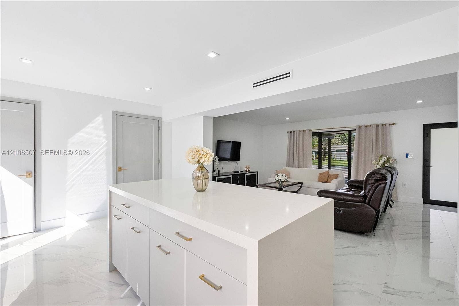 451 SW 38th Terrace, #1, Fort Lauderdale, Fort Lauderdale, FL 33312 Center island featuring a white stone-surface countertop, recessed ceiling lighting, light-toned cabinetry with metallic hardware, and white tile flooring