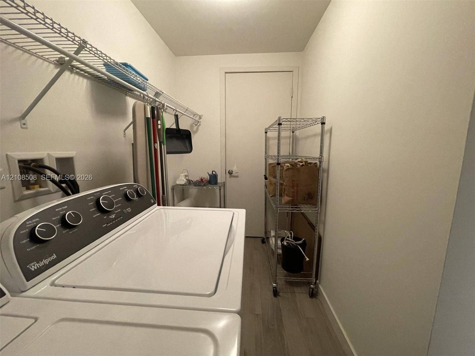 Laundry area featuring wood-finish flooring and integrated wall-mounted wire shelving