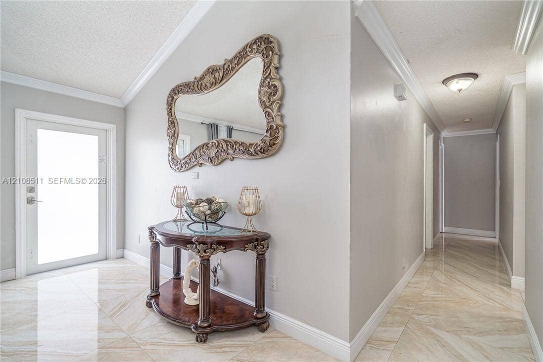 Miramar, Miramar, FL 33025 Entryway featuring large-format tile flooring, vaulted ceilings, crown molding, and a neutral color palette