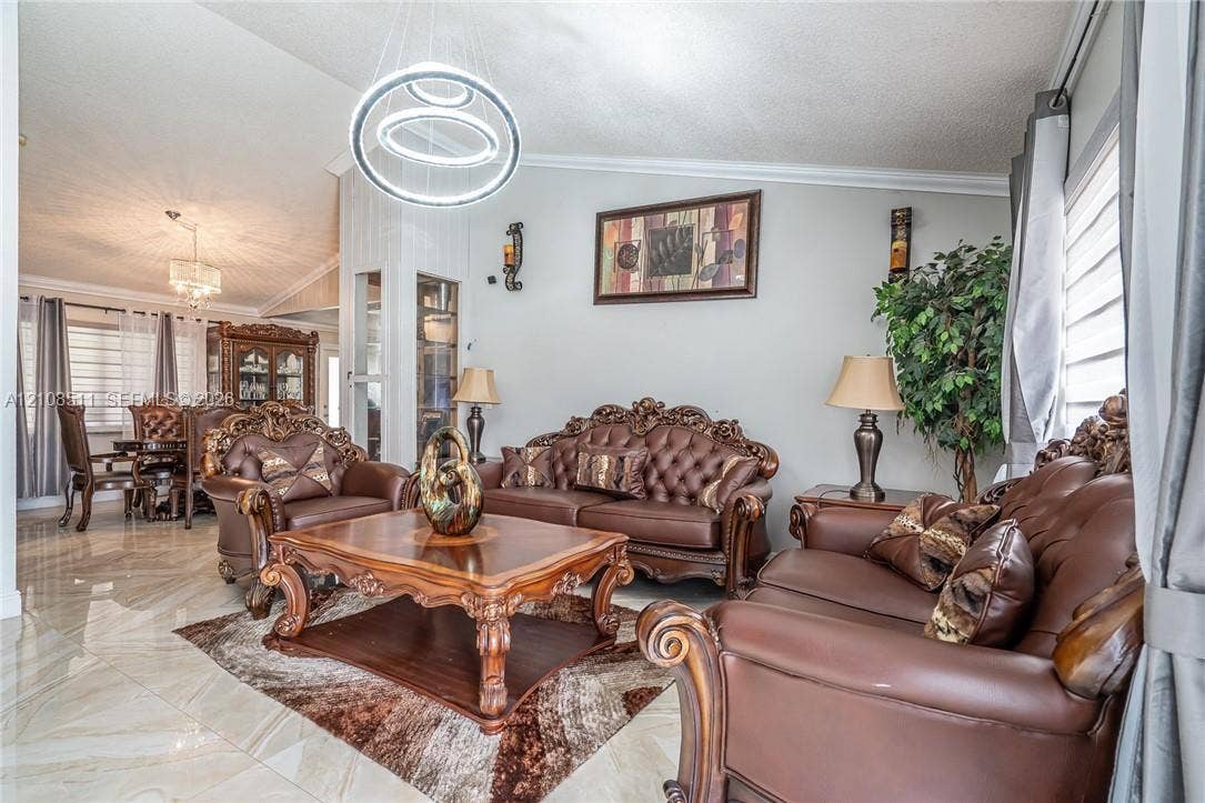 Miramar, Miramar, FL 33025 Vaulted ceilings, large-format tile flooring, modern dual-ring LED chandelier, and built-in glass-paneled display cabinetry