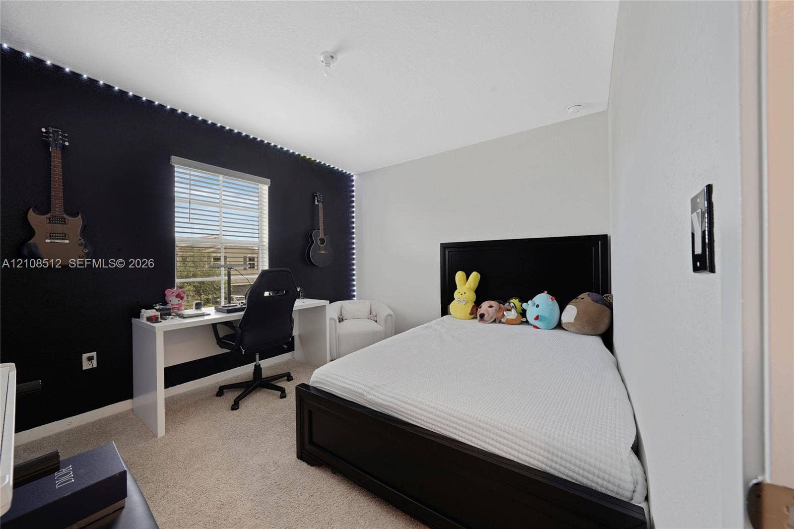 Bedroom featuring a neutral carpet, dual-tone walls, integrated perimeter ceiling lighting, and a single-pane window with blinds