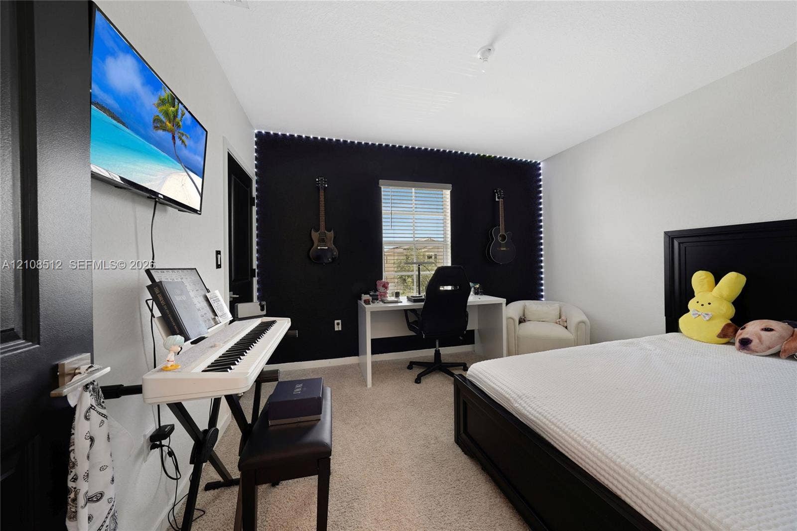 Bedroom featuring neutral-toned carpeting, high-contrast accent wall, and a single-pane window with horizontal blinds
