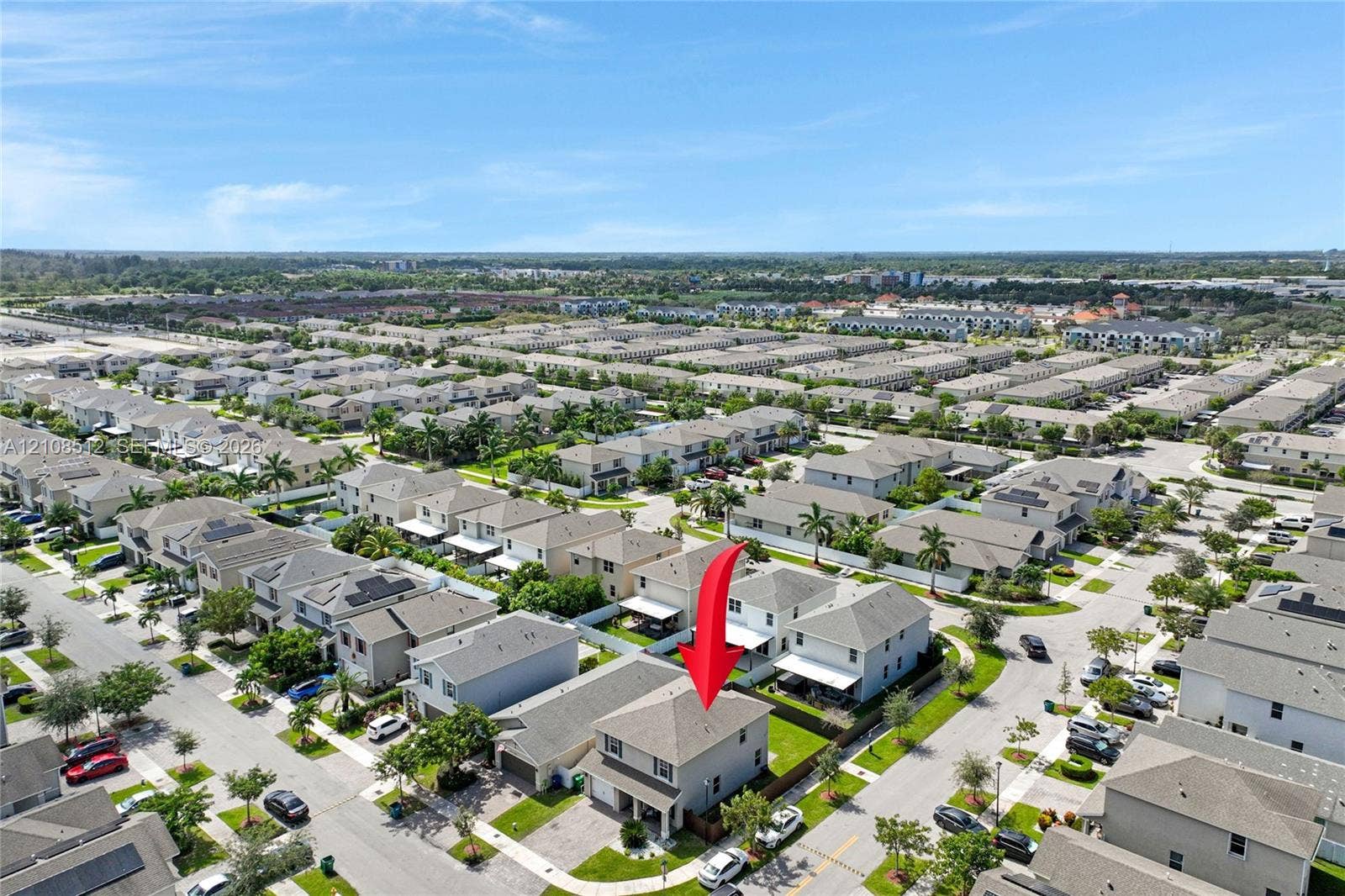 Two-story residence featuring a hip roof, stucco exterior, attached garage, and paved driveway