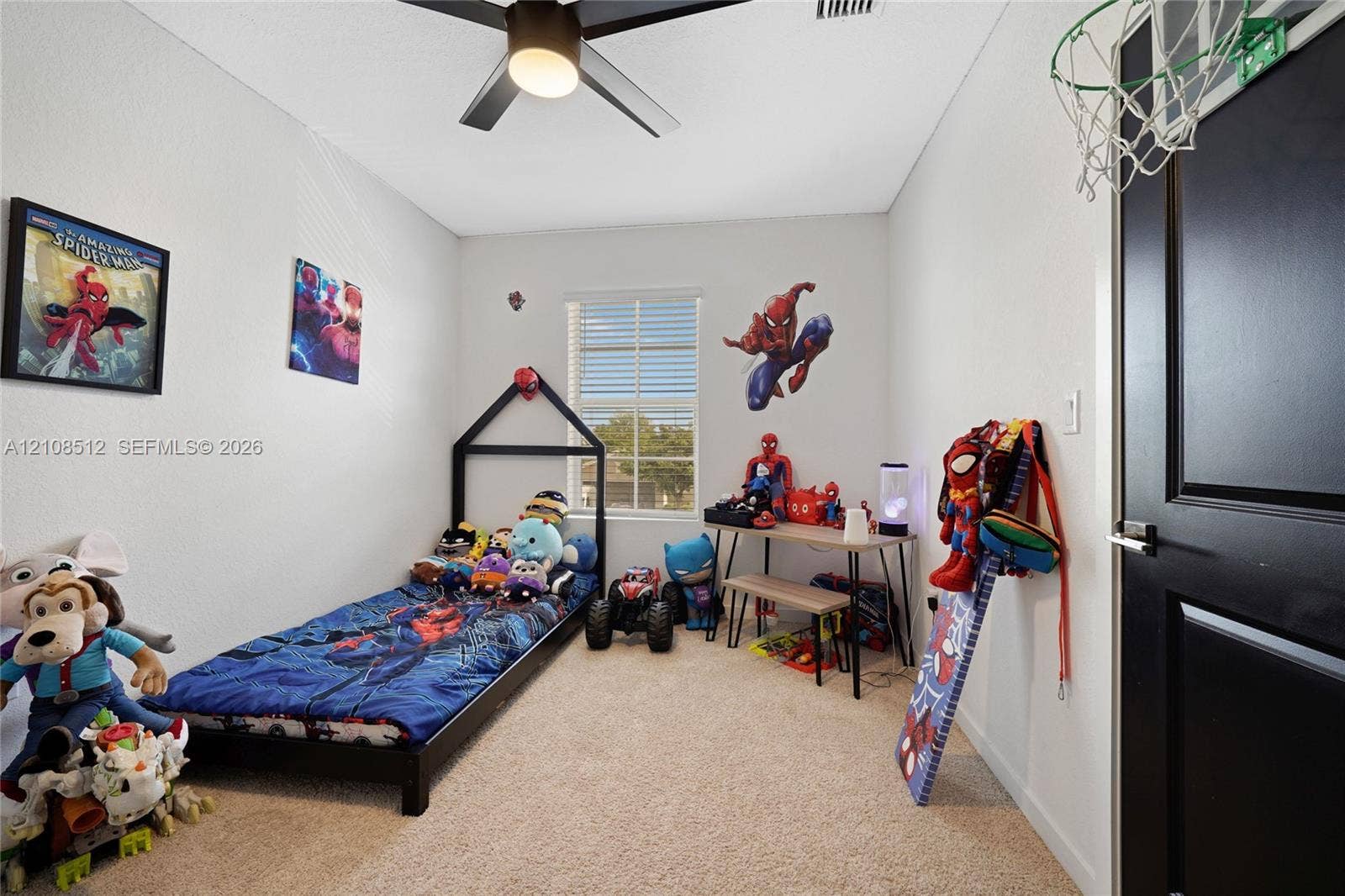 Neutral wall finish, carpeted flooring, window with blinds, ceiling fan with integrated light fixture, and door with contrasting trim