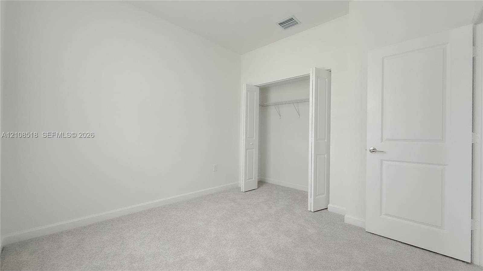 27733 SW 155th Court, #27733, Homestead, Homestead, FL 33032 Neutral-toned carpeting, two-panel interior door, and walk-in closet with built-in shelving
