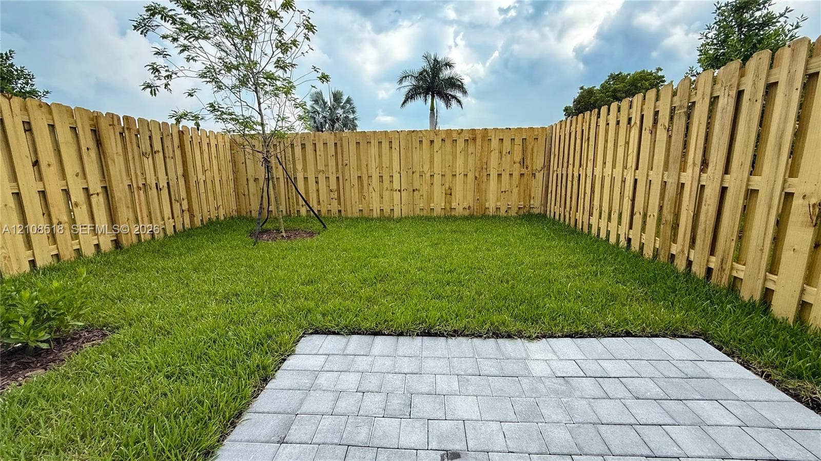 27733 SW 155th Court, #27733, Homestead, Homestead, FL 33032 Fenced backyard featuring a manicured lawn, paver patio, and young tree