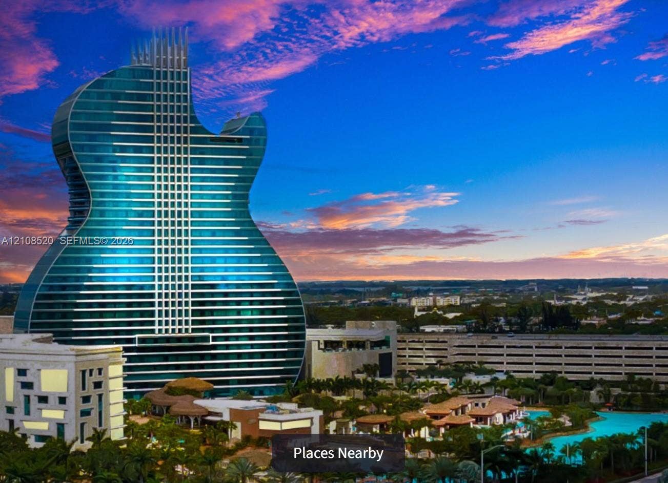 4536 SW 24th Avenue, Dania, Dania Beach, FL 33312 Iconic guitar-shaped high-rise structure featuring a glass-paneled exterior, expansive swimming pool, tropical landscaping, and multi-level parking facility