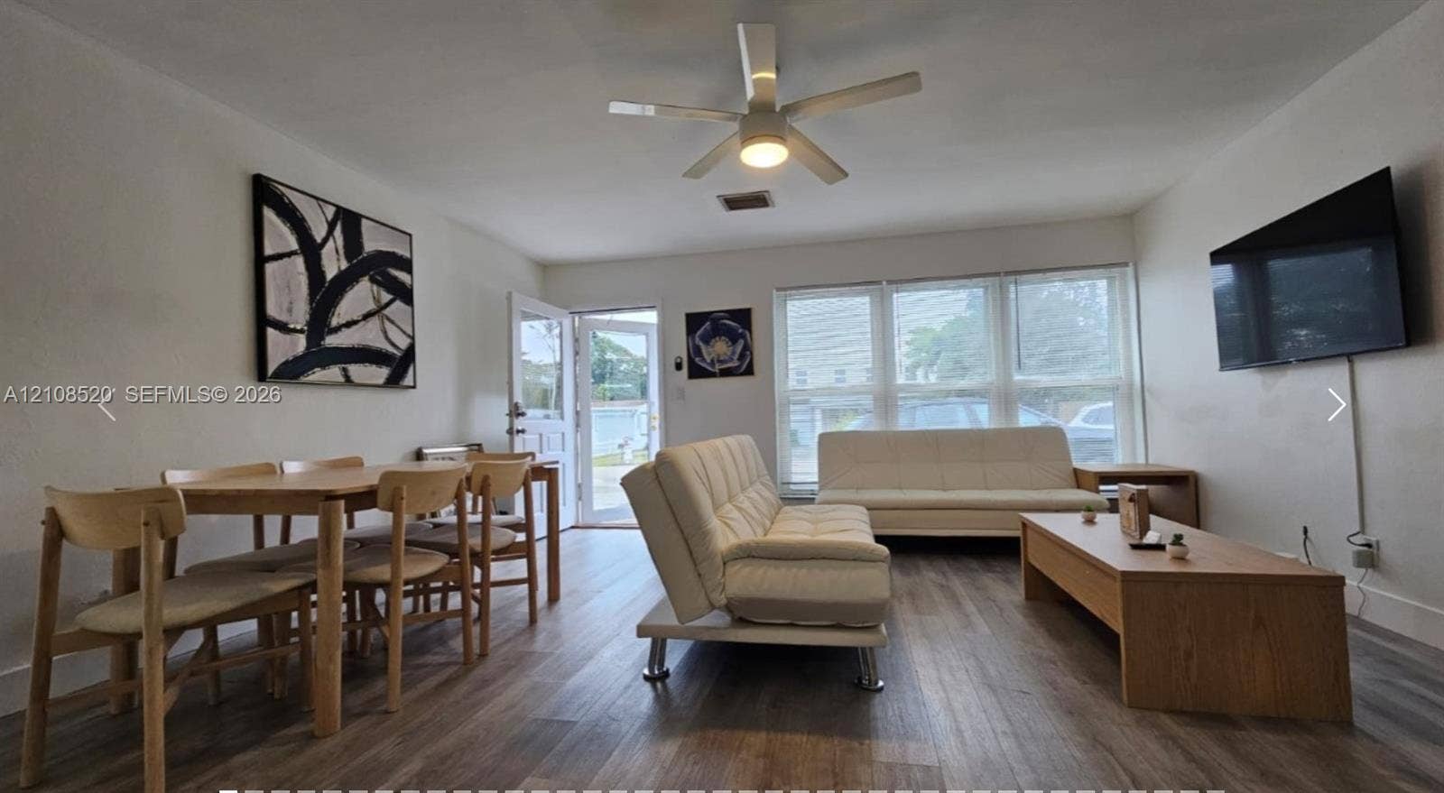 4536 SW 24th Avenue, Dania, Dania Beach, FL 33312 Living area featuring wood-finish flooring, a multi-pane window configuration, and a central ceiling fan