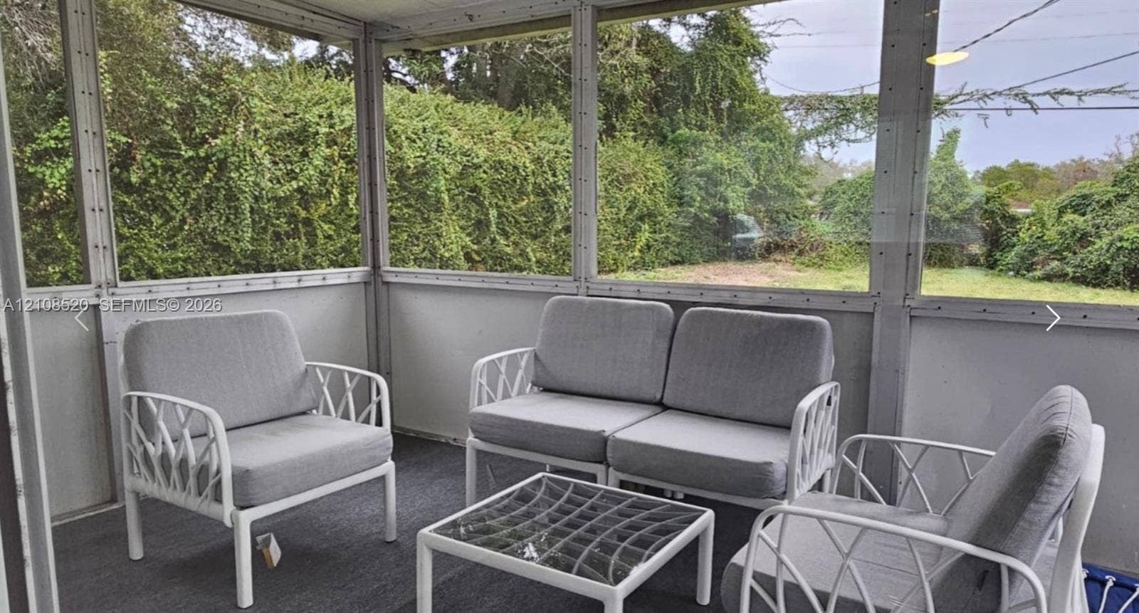 4536 SW 24th Avenue, Dania, Dania Beach, FL 33312 Screened-in enclosure featuring wall-to-wall mesh screening, a solid knee wall, and carpeting
