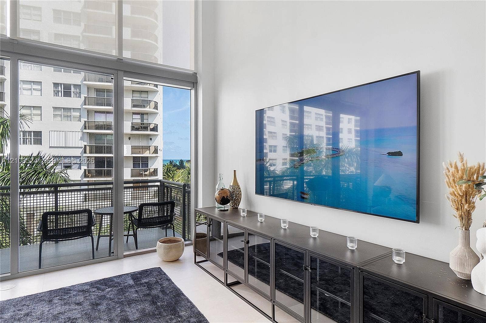 6000 Collins Avenue, #527, Miami Beach, FL 33140 Floor-to-ceiling windows, double-height ceilings, and a private balcony with metal railings