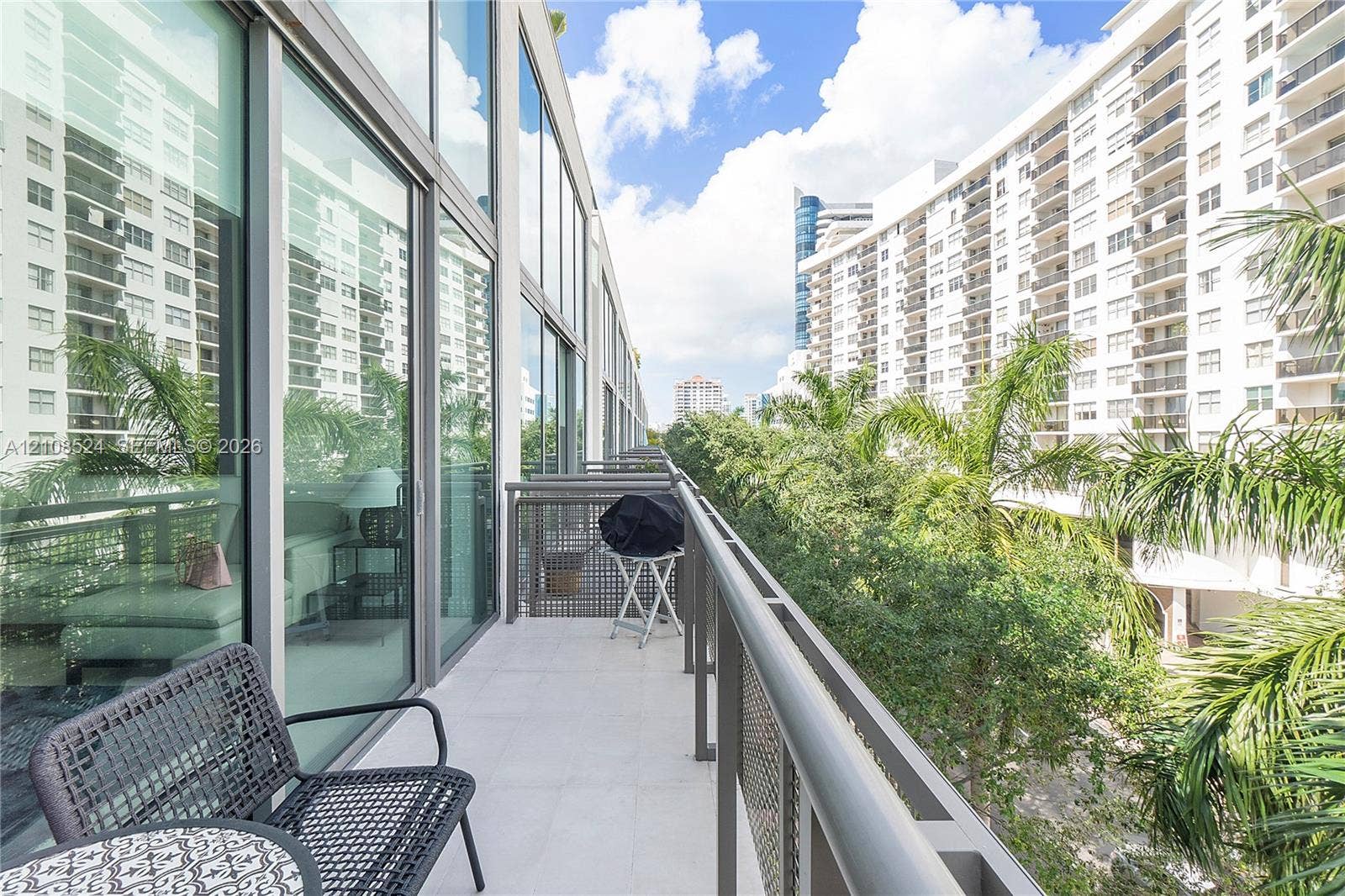 6000 Collins Avenue, #527, Miami Beach, FL 33140 Covered terrace with tile flooring, floor-to-ceiling glass panel walls, and metal railings
