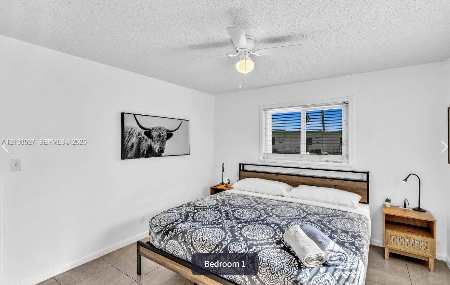 4549 SW 24th Avenue, Dania, Dania Beach, FL 33312 Neutral-toned interior featuring large-format tile flooring, a white ceiling-mounted light fixture with an integrated fan, and a single-hung window with white framing