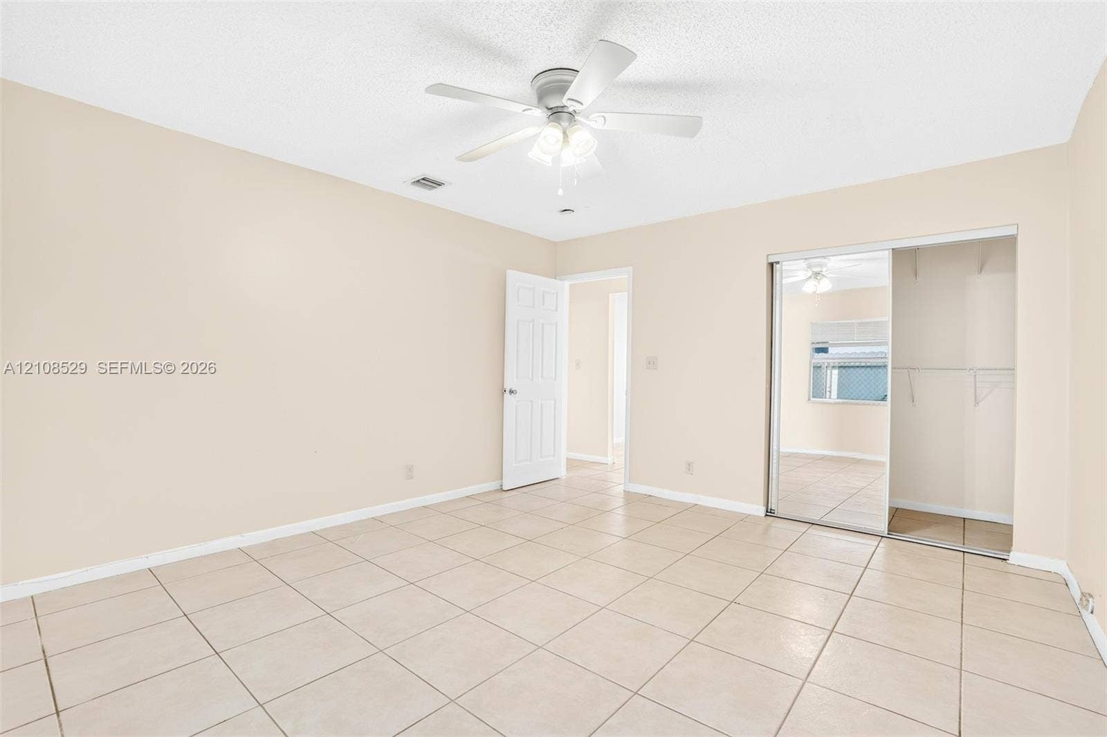1015 SW 4th Avenue, #A, Fort Lauderdale, Fort Lauderdale, FL 33315 Interior space featuring neutral-toned tile flooring, a central ceiling fan with integrated lighting, and a closet with sliding mirrored doors