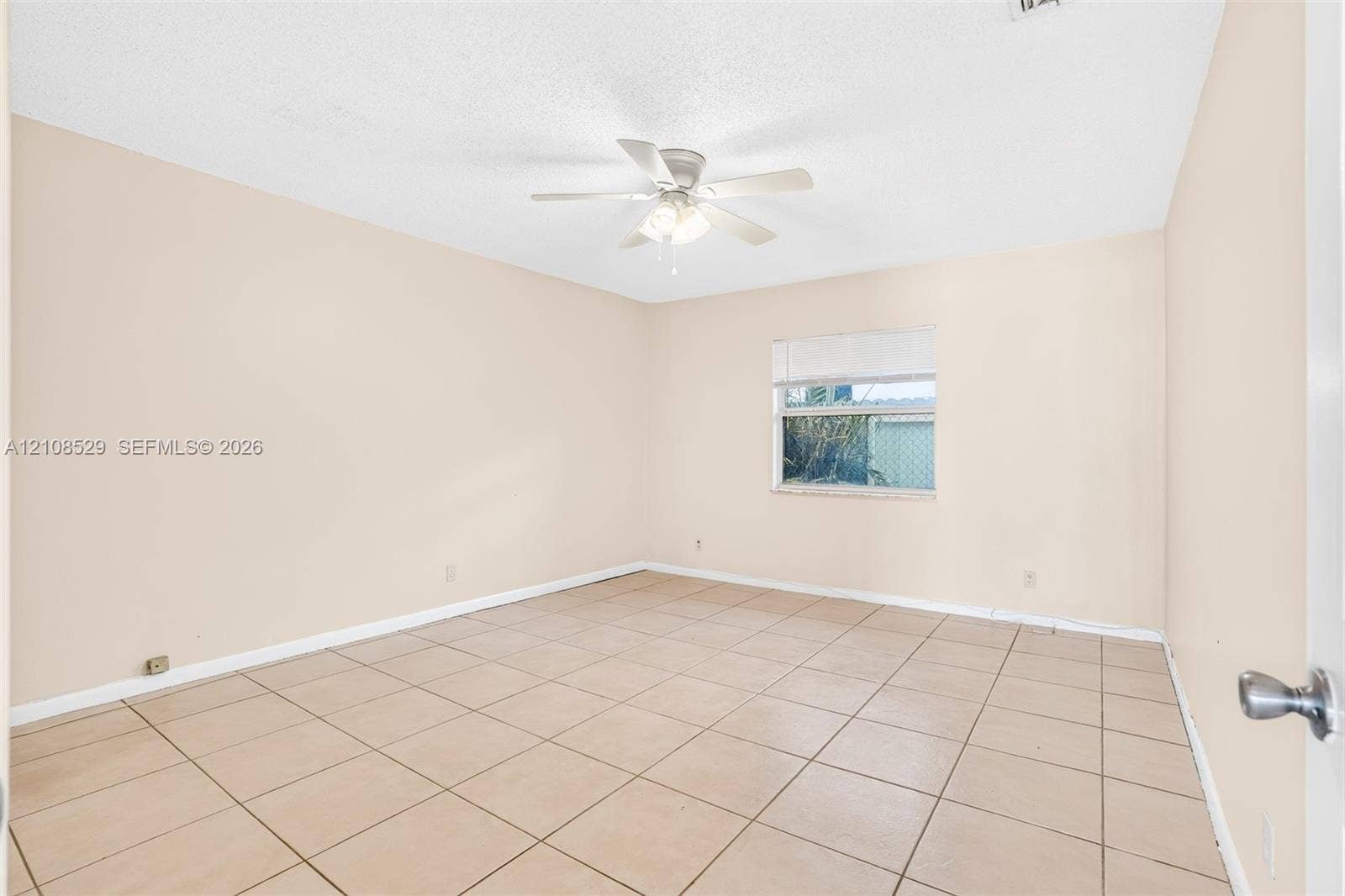 1015 SW 4th Avenue, #A, Fort Lauderdale, Fort Lauderdale, FL 33315 Neutral-toned interior space featuring ceramic tile flooring, a multi-blade ceiling fan with integrated lighting, and a single window with horizontal blinds