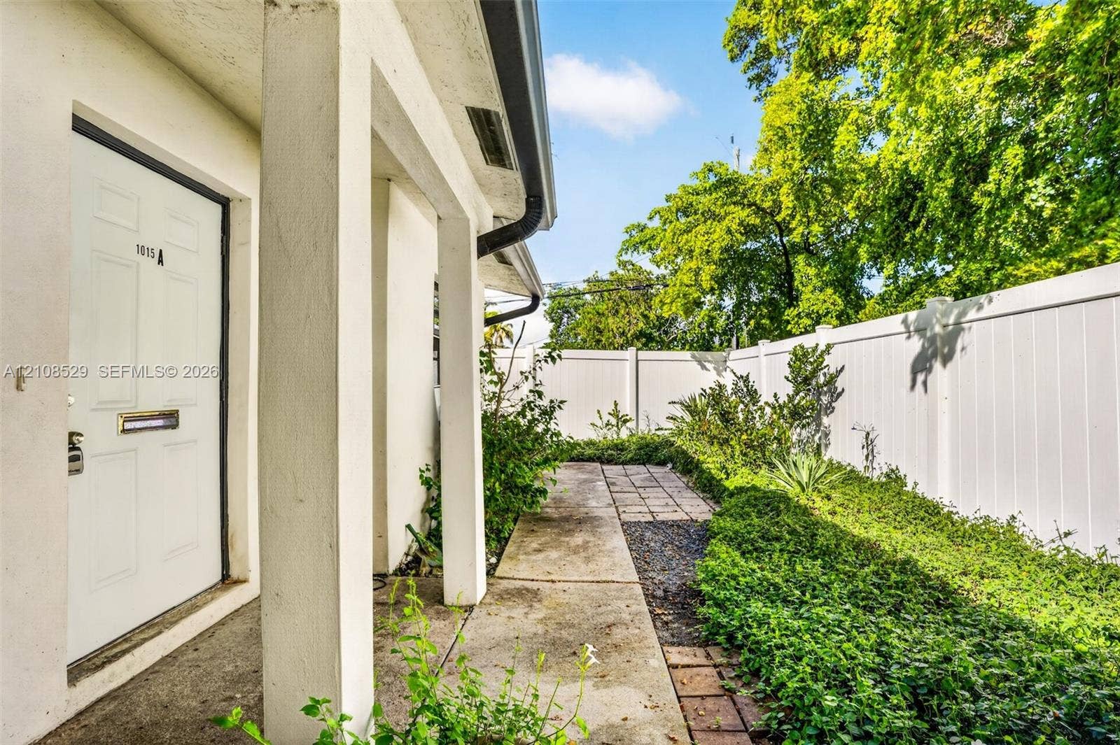 1015 SW 4th Avenue, #A, Fort Lauderdale, Fort Lauderdale, FL 33315 Covered entryway featuring structural pillars, concrete walkway, and white vinyl perimeter fencing
