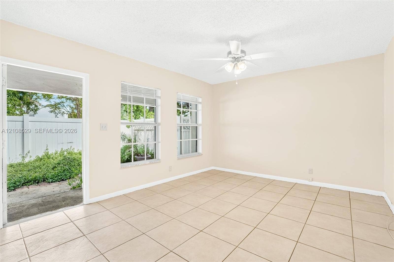 1015 SW 4th Avenue, #A, Fort Lauderdale, Fort Lauderdale, FL 33315 Interior space featuring neutral wall paint, ceramic tile flooring, two multi-pane windows, and a ceiling-mounted light fixture with fan