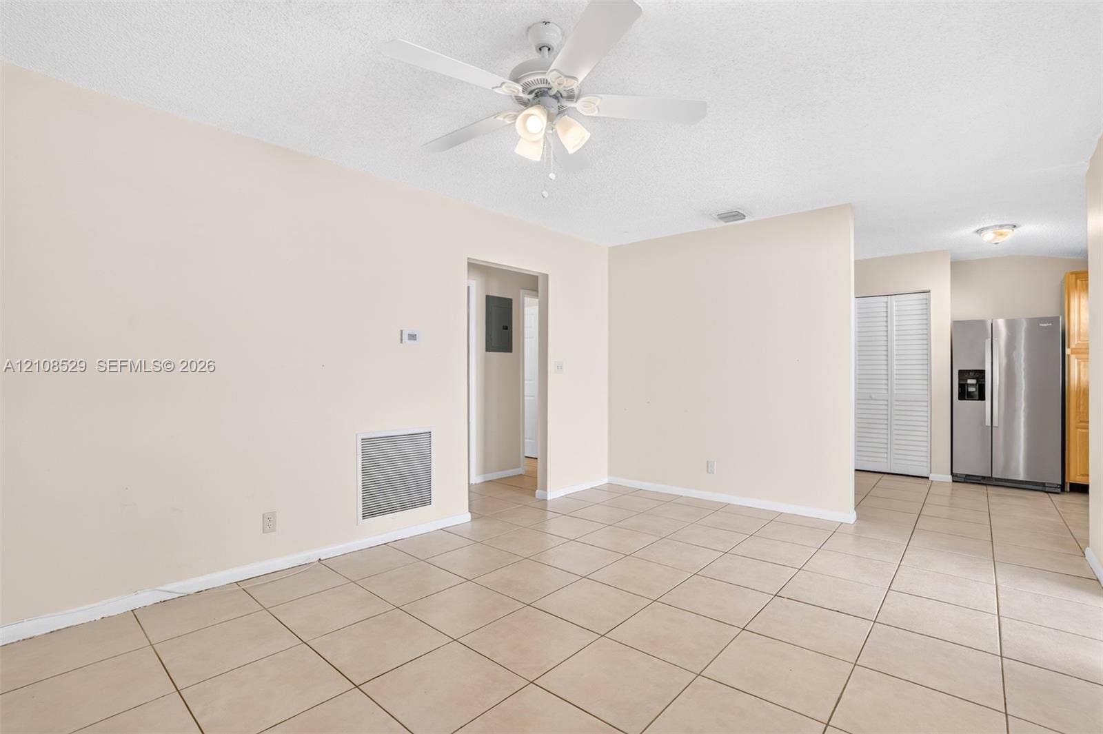 1015 SW 4th Avenue, #A, Fort Lauderdale, Fort Lauderdale, FL 33315 Open interior space featuring neutral tile flooring, a multi-light ceiling fan, and a stainless steel refrigerator