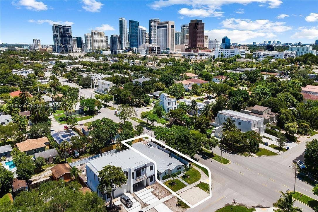 1015 SW 4th Avenue, #A, Fort Lauderdale, Fort Lauderdale, FL 33315 Aerial perspective of a multi-level structure featuring a flat roof, white exterior cladding, covered ground-level parking, and a concrete driveway