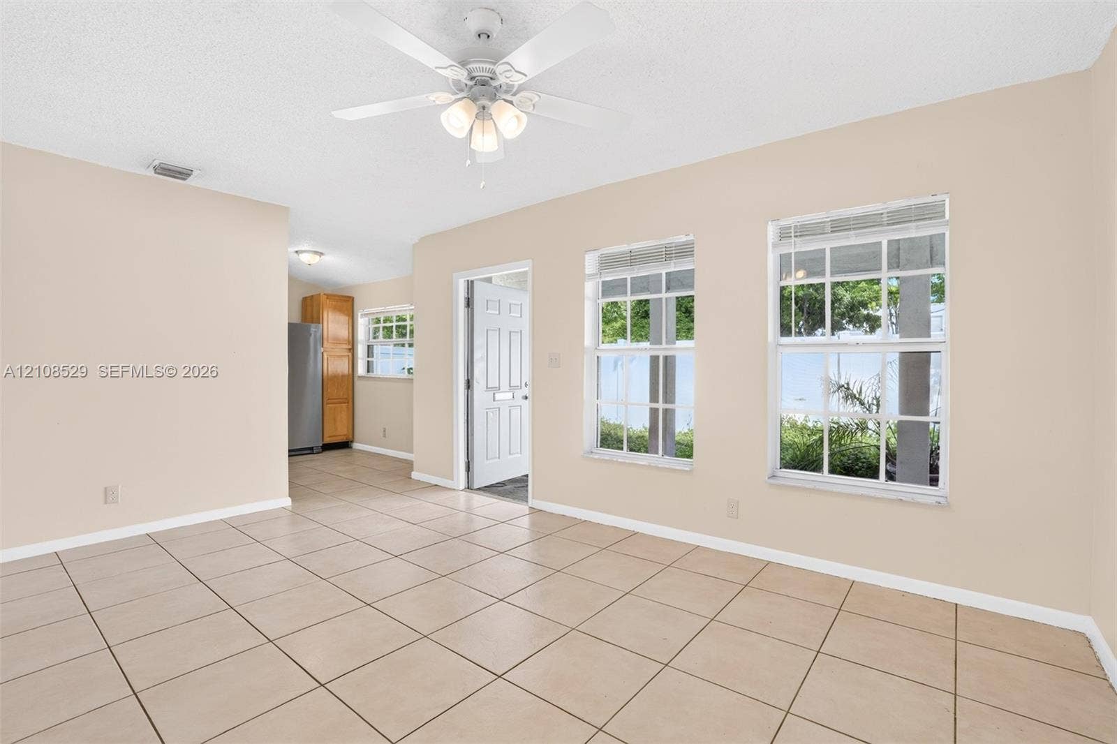 1015 SW 4th Avenue, #A, Fort Lauderdale, Fort Lauderdale, FL 33315 Interior featuring large-format tile flooring, a multi-blade ceiling fan with integrated lighting, and multiple windows with white muntin grids