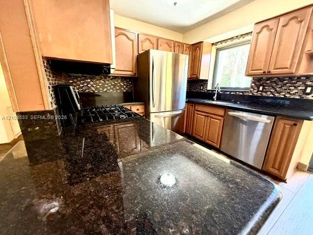 1124 NE 7th Street, Hallandale Beach, Hallandale Beach, FL 33009 Kitchen featuring natural wood cabinetry, stone countertops, mosaic tile backsplash, and stainless steel appliances