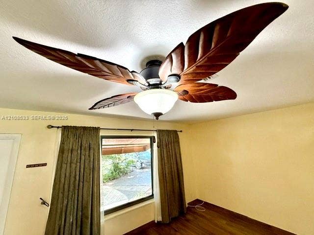 1124 NE 7th Street, Hallandale Beach, Hallandale Beach, FL 33009 Ceiling fan featuring decorative leaf-shaped blades and a central dome light fixture, accompanied by wood-finish flooring