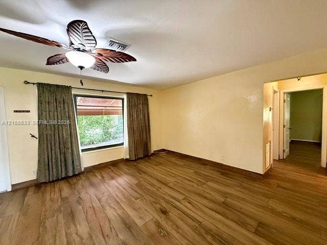 1124 NE 7th Street, Hallandale Beach, Hallandale Beach, FL 33009 Room interior featuring wood-finish flooring, a decorative leaf-blade ceiling fan, and a large window