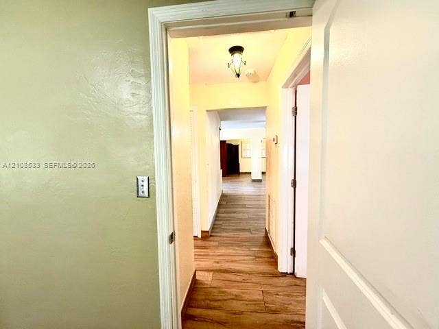 1124 NE 7th Street, Hallandale Beach, Hallandale Beach, FL 33009 Interior hallway featuring wood-finish flooring, textured walls, and a decorative flush-mount ceiling fixture