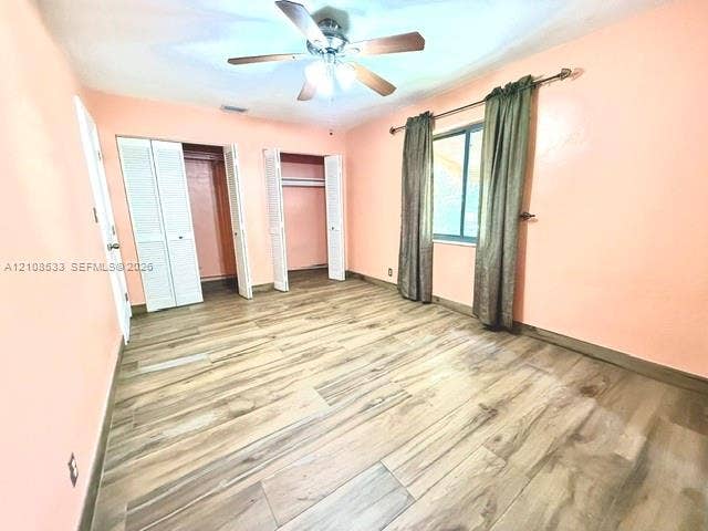 1124 NE 7th Street, Hallandale Beach, Hallandale Beach, FL 33009 Wood-finish flooring, dual closets with louvered doors, and a ceiling-mounted light fixture with fan