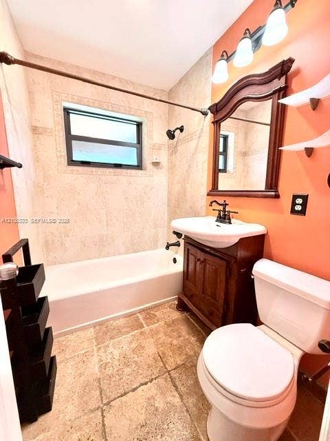 1124 NE 7th Street, Hallandale Beach, Hallandale Beach, FL 33009 Bathroom featuring tile flooring, a tub-shower combination with tiled surround, a wood-finish vanity with a drop-in sink, an ornate wood-framed wall mirror, and three-bulb vanity lighting